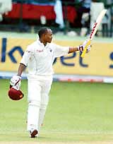 West Indies batsman Brian Lara raises his bat after scoring a century against Pakistan on the first day of the first Test at Kensington Oval in Bridgetown, Barbados, on Thursday