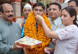 Raghav Kapur, a student of DAV Senior Secondary School, Amritsar, who stood first in the matriculation examination of the Punjab State Education Board, is ffered sweets by his mother.