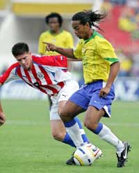 Brazilian forward Ronaldinho battles for the ball with Paraguay�s Cesar Ramirez 