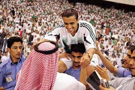 Saudi Arabia�s Mohammed Alshalboub is carried by supporters after winning their soccer match against Uzbekistan