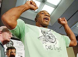 Former world boxing champion Mike Tyson flexes muscles for his fans after his weigh-in in Washington DC on Thursday
