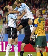 Argentina�s Luciano Figueroa celebrates with team-mate Esteban Cambiasso after scoring a goal while Australia�s Craig Moore looks on during their Confederations Cup soccer match in Nuremberg, Germany