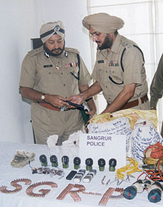 The Director-General of Police, Punjab, Mr S.S. Virk (left), looks at arms and ammunition seized from militants in the state in the past 15 days, in Chandigarh on Monday.