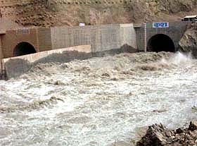 Water gushes out of twin diversion tunnels of the Kol Dam project near Sundernagar in Himachal Pradesh