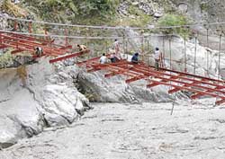 Men at work perched precariously on a new bridge across the Sutlej at Wangtoo in Kinnaur district on Thursday.