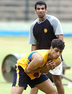 Indian pace bowler Ashish Nehra takes a catch while Zaheer Khan looks on during a fielding practice session 