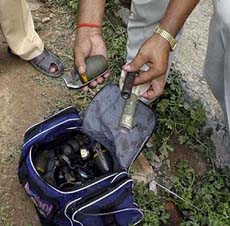A policeman inspects a bag containing grenades which were recovered from the slain terrorists who made a failed attempt to enter the makeshift Ram temple complex in Ayodhya on Tuesday