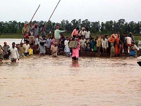Villagers flee the flooded areas by boats from the villages located on the Indo-Pak border on Thursday.