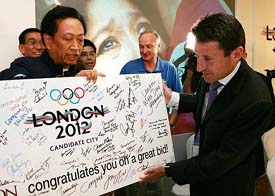London�s bid leader and former Olympic champion Sebastian Coe receives a congratulatory placard after a press conference in Singapore on Thursday after London won the right to host 