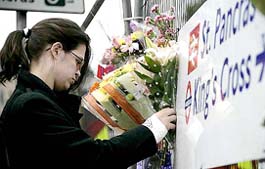 A woman lays flowers at King’s Cross Station in central London on Friday as a mark of respect to those who were killed in Thursday’s bombings.