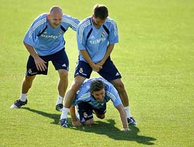 Real Madrid player David Beckham squeezes under the legs of team-mate Michael Owen as Thomas Gravesen looks on during their training session at Las Rozas, near Madrid, on Tuesday
