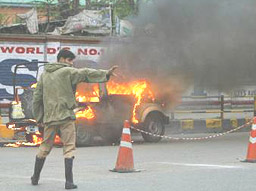 A policeman runs towards a paramilitary jeep in flames after a militant attack in Srinagar on Friday.