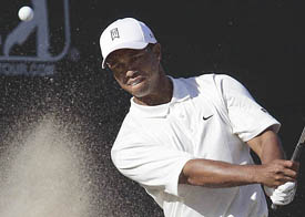 Tiger Woods hits out of a bunker on the 18th green during the third round