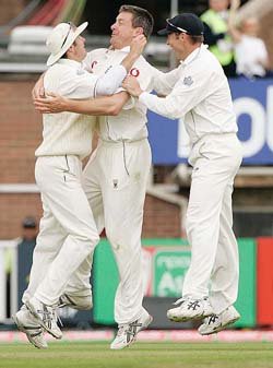 England's Ashley Giles celebrates with Michael Vaughan and Marcus Trescothick after taking the wicket of Australian captain Ricky Ponting 