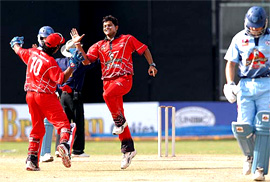 Air India skipper Suresh Raina and wicketkeeper Dinesh Karthik celebrate the dismissal of New South Wales batsman Murray Creed