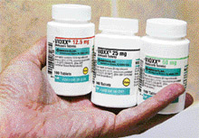 A pharmacist holds bottles of prescription arthritis and pain medication Vioxx in this file picture. A jury in the first civil trial against Merck & Co.�s popular painkiller Vioxx on Friday found the pharmaceutical company liable for the 2001 death of a Texas man, awarding his widow $253.4 million as damages.