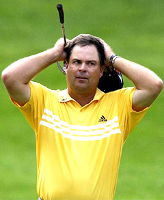 Kenny Perry of the USA gestures after a siren sounds for the suspension of play during the third round of the WGC-NEC Invitational golf tournament