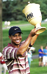 Tiger Woods holds the trophy after winning the NEC Invitational golf tournament at Firestone Country Club in Akron, Ohio