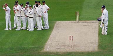 Australian players await the third umpire's decision on their appeal for the dismissal of England's Andrew Strauss during the first day of the fourth Ashes Test at Trent Bridge