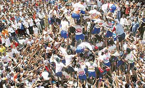 People watch Lord Krishna devotees in the process of making a human- pyramid to break a “dahi- handi” during a contest in Mumbai on Saturday.