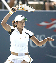 Sania Mirza of India hits a return shot to Marion Bartoli of France during their third-round match
