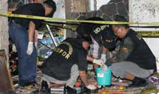 Indonesian security officials inspect the scene of an explosion
