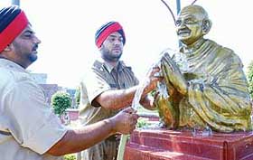 ANNUAL BATHING: Two constables of the Punjab Police wash a statue of Mahatma Gandhi on the eve of Gandhi Jayanti at Sadbhavana Sikha, Police Lines, Patiala