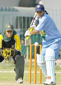 Karuna Jain Vijaykumar (right) prepares to play a shot as Pakistani wicketkeeper Sana Javeed looks on during the third one day international match at the Gaddafi Stadium in Lahore on Saturday. 