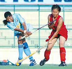 A Malaysian player tries to tackle an Indian player during the opening match of the 7th Indira Gandhi International Gold Cup Hockey Tournament in New Delhi on Saturday. India won 2-1.