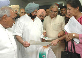 The Chief Ministers of Punjab and Haryana, Capt Amarinder Singh and Mr Bhupinder Singh Hooda, go through the publicity material for the Congress Chief Ministers� conclave as Mrs Ambika Soni and Mr Moti Lal Vora look on in Chandigarh on Monday.