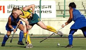 An Australian player (in yellow) tackles a Malaysian player during their match at the 7th Indira Gandhi International Gold Cup Hockey Tournament in New Delhi