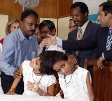 Team of doctors stands behind Saba and Farah, the conjoined twin sisters with their father of Samanpura in Patna, Bihar, in a hospital in New Delhi, on Tuesday. Dr Benjamin Carson of the John Hopkins Children’s Centre, USA, is second from right