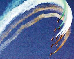 Aircraft of the Surya Kiran aerobatic team of the Indian Air Force 'draw' colourful patterns in New Delhi during the final rehearsal for the Air Force Day celebrations on Thursday.