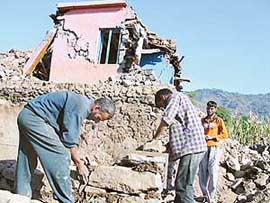Self help: Instead of waiting for government aid Khadam Hussain has started constructing a dwelling near his quake-damaged house in the Karmara village of Poonch district.