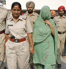 Dr Ravdeep Kaur, a suspect in the Judge Vijay Singh murder case, is escorted out of the court by the police in Patiala