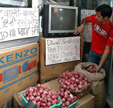 A buyer looks at goods at a home appliance shop which is offering 10-kg onion as free gift on every purchase of television sets or other similar appliances, in Amritsar on Wednesday