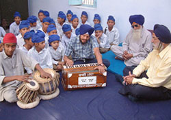 Gurkhas from Nepal, who were rendered orphans and converted to Sikhism, sing hymns from Guru Granth Sahib at the Central Khalsa Orphanage, Amritsar, on Thursday. 