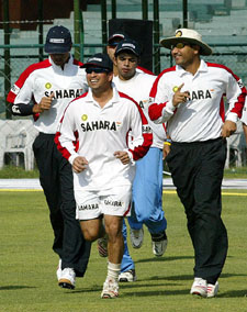Sachin Tendulkar and Virender Sehwag along with team-mates warm up during a practice session at the Mansingh Stadium in Jaipur