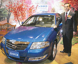 Mr Carlos Ghosn, President and CEO, Renault, stands next to Renault Samsung's SM3 car after a news conference in Seoul on Thursday. 