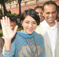 Newly-elected Congress MP from the North-West constituency of Mumbai Priya Dutt, with husband Owen Roncom, waves to mediapersons as she arrives to attend the winter session of Parliament in New Delhi on Thursday.