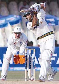 Pakistani batsman Mohammad Yousuf plays a shot as England wicketkeeper Geraint Jones looks on during the second day of the third Test at the Gaddafi Stadium in Lahore