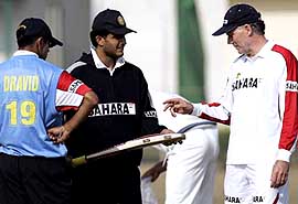 Sourav Ganguly chats with coach Greg Chappell as Rahul Dravid looks on during a practice session in New Delhi