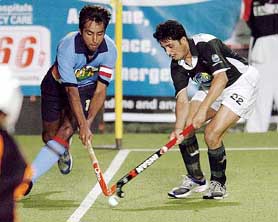 India�s Gagan Ajit Singh (left) and Pakistan�s Ashraf Zeeshan fight for the ball during their match in the Champions Trophy in Chennai on Sunday. India won 3-2.