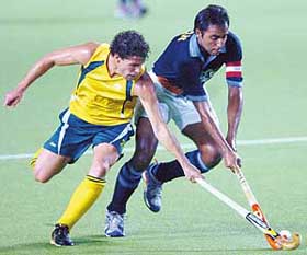 Gagan Ajit Singh and Brent Livermore of Australia fight for the ball during their match in the Champions Trophy hockey tournament in Chennai on Tuesday