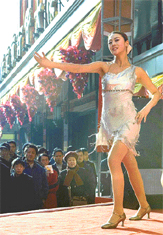 A Chinese dancer wearing a light dress braves chilly weather to perform during pre-Chrismas sales promotion on the streets of Beijing on Sunday.