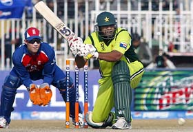 Inzamam-ul-Haq plays a sweep shot as England wicketkeeper Geraint Jones looks on during the fourth one-day match between Pakistan and England in Rawalpindi