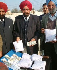 Mr Sukhdev Singh, SSP, Special Narcotics Cell (Centre), shows packets of heroin and dollars seized from two smugglers in Amritsar on Sunday.