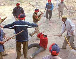 Policemen rain lathis on a protester during a demonstration by vegetable and fruit merchants at Old Fruit Market in Amritsar.