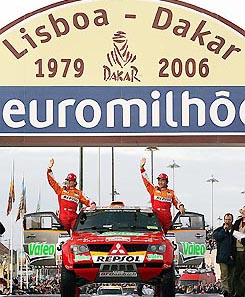 Japanese driver Hiroshi Masuoka  and his French co-driver Pascal Maimon wave to the crowd on their Mitsubishi car at the start of the 28th edition of the Dakar rally in Lisbon on Saturday