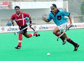A Surjit Hockey Academy player gets past a CRPF player during a match in the Surjit Hockey Tournament in Jalandhar on Saturday